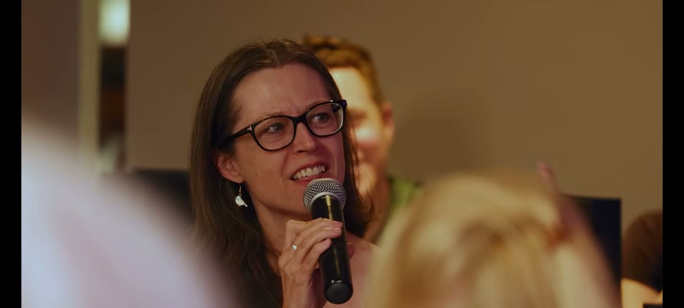 A seminar guest asking a question on the microphone
